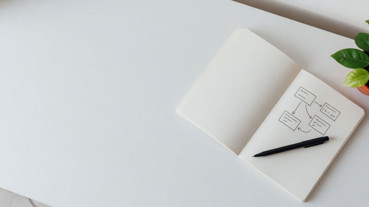 Minimal desk with notebook and process sketch